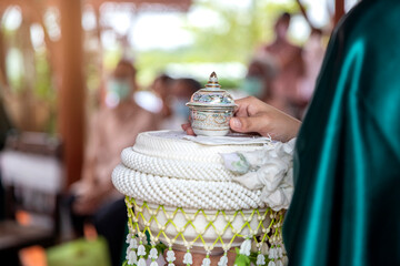 woman's hand holding wedding ceremony holy grail cup in Thai tradition ceremony