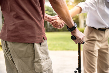 Young Woman Assisting Her  Father While Walking outdoors at home