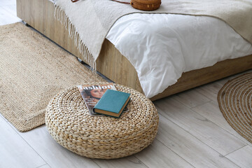Rattan pouf with book and magazine in bedroom