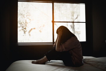 sad woman suffering depression insomnia awake and sit alone on the bed in bedroom. sexual...