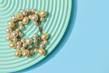 Showcase pedestal with pearl bracelet on blue background
