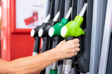 Woman at self service fuel pump in european gas station - inflation, rising prices, economy,...