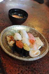 Delicious handmade nigiri sushi set with raw fish and rice on a plate in a restaurant in Japan 