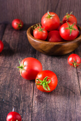 Ripe organic tomatoes on a wooden table. Harvest and local products. Vertical view