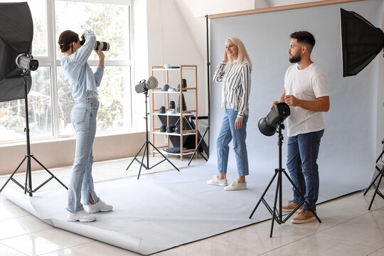 Female photographer and her assistant working with mature woman in studio