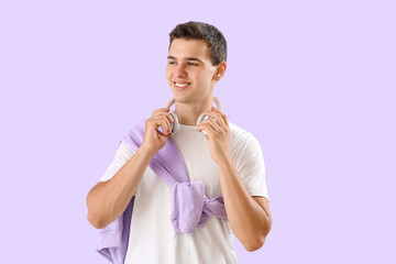 Teenage boy with headphones on lilac background