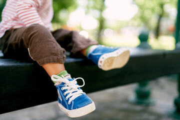 Little baby feet in blue sneakers. Close-up. High quality photo