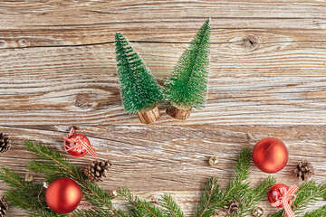Christmas composition with fir tree branches, pine cones and red balls on wooden background. Christmas frame, flat lay. Xmas greeting banner with copy space