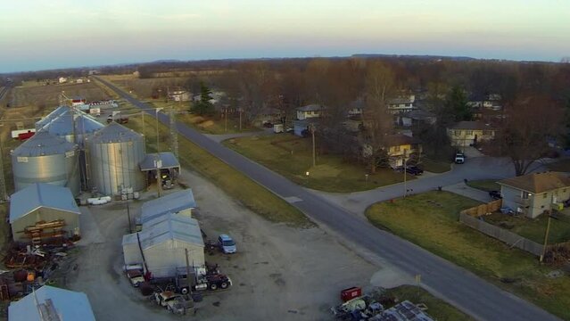Aerial Tilt Up Shot Of Industries By Street In City During Sunset - Buckner, Missouri
