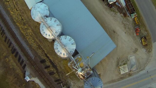 Aerial Top Backwards Shot Of Silo By Railroad Track, Drone Flying Over City - Buckner, Missouri