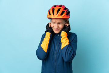 Young cyclist woman isolated on blue background frustrated and covering ears