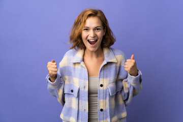 Young Georgian woman isolated on purple background celebrating a victory in winner position
