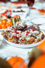 Salads on the festive table, eggplant rolls decorated with cheese and pomegranate serving, tasty snacks on the table, selective focus