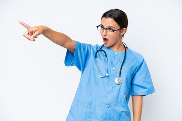 Young nurse woman isolated on white background pointing away