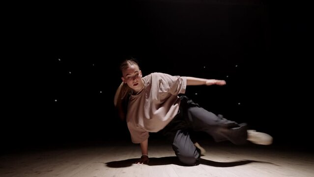 active teen girl is performing modern street dance, dancing freestyle, breaking and hip-hop