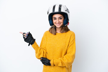 Young caucasian woman with a motorcycle helmet isolated on white background pointing finger to the side