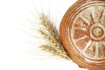 Round yeast-free rye bread and ears of rye on a white isolated background. Top view. selective focus