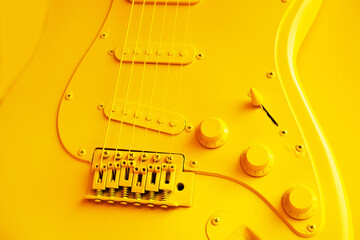 Fragment of a yellow electric guitar. An idea for using old items and restoring them to decorate different spaces. Painting of musical instruments. Close-up