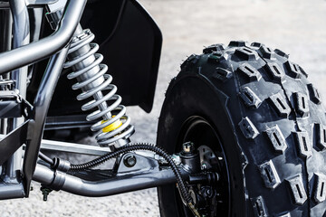 A fragment of the shock absorber and wheel of an ATV. Details of the vehicle close-up. selective focus