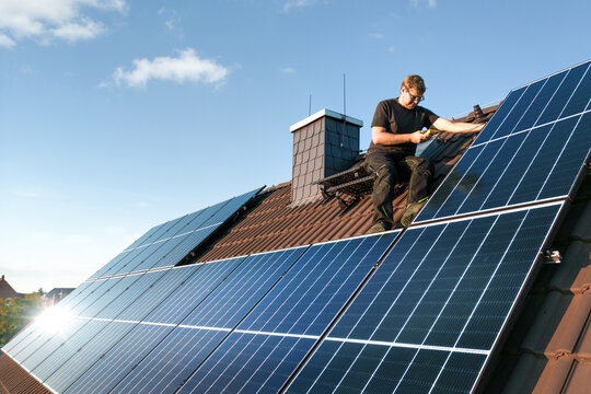 Technician checking the photovoltaic system on the roof of a house