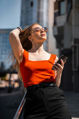 Beautiful woman with glasses and walking and talking on mobile phone. Wireless communication.