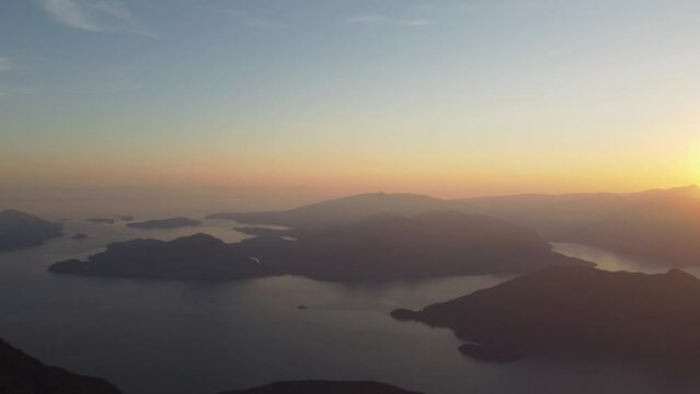 Sunset Aerial Drone from Deeks Peak with Howe Sound Fjord Rocky Landscape with Blue and Orange Sky in Pacific Ranges Canada BC 4K