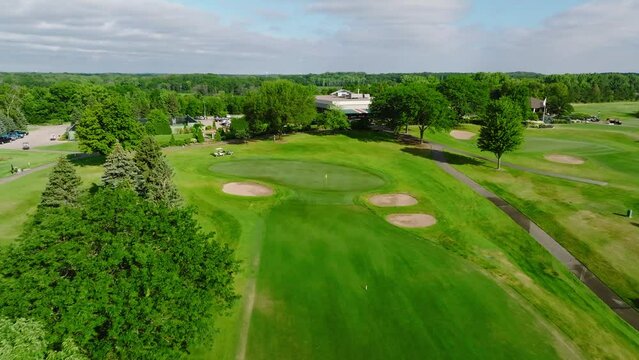 push in drone shot of a golf green with green side bunkers at a golf club