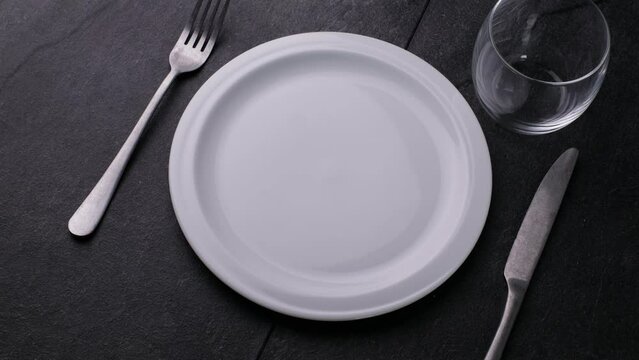 Classic serving tableware on the table, white plate fork and knife