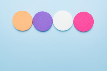 Makeup trendy background with copy space. Set of multicolored round cosmetic sponges for liquid foundation or compact powder. Face skin visage, accessory for makeup