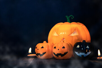 Halloween pumpkin head jack with burning candles in scary deep night, space for text. Halloween decor