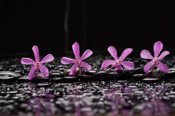 Gartenposter spa still life of with macro of orchid and zen black stones wet background  © Mee Ting