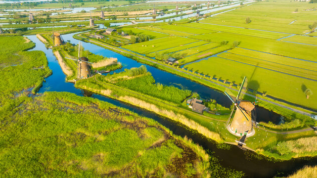 An aerial view of the windmill. Kinderdijk national park. Canals with water for agriculture. Fields and meadows. Landscape from the air.
