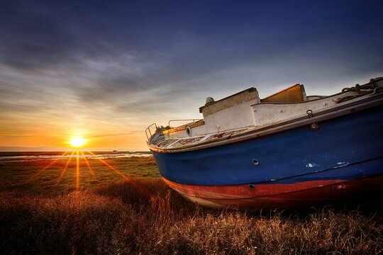 Abandoned boat during sunset on Heswall marsh coast, in the Wirral