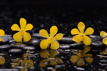 Keuken spatwand met foto spa still life of with  yellow orchid , and zen black stones wet background  © Mee Ting