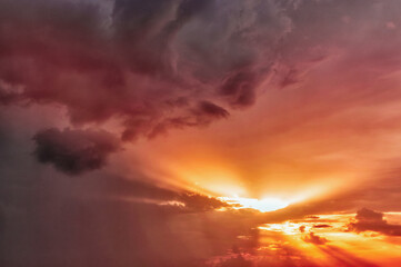 Obraz premium summer orange sunset sky with dark clouds.