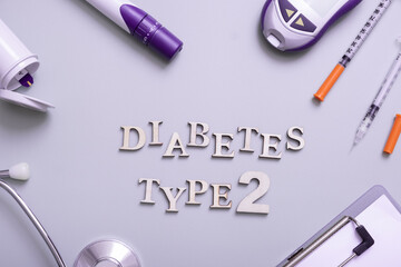 Inscription diabetes type 2 and glucometer, syringes and medical equipment on a colored background, top view