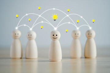 Idea. Teamwork. Happy wooden person figure standing with team and they have light bulb symbol for...