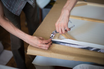 Obraz premium close up of a person hands stretching the canvas on the stretcher
