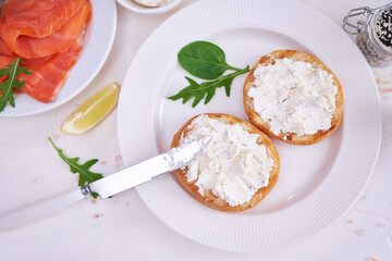 Making cream cheese and salmon toatst - woman smearing cream cheese on a grilled bun