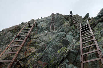 日本百名山の槍ヶ岳の梯子を登る登山者