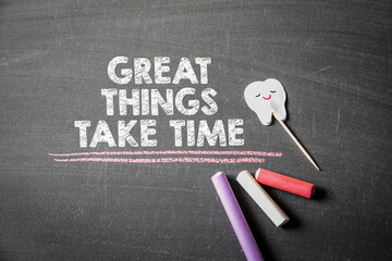 Great things take time. Text on a dark chalk board