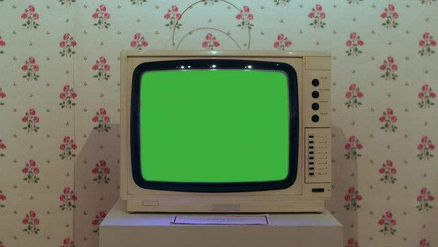 A 1980stelevision set. The TV is displaying green screen for chroma key
