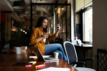 Fototapeta na wymiar Young businesswoman drinking coffee in her office. Woman enjoy in coffee break.