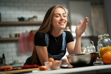 Young woman in kitchen. Beautiful woman making delicious food..