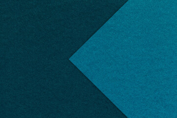 Texture of navy blue paper background, half two colors with dark turquoise arrow, macro. Craft...