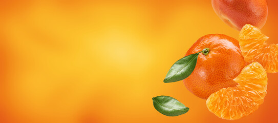 mandarines with slices and leaves flying on orange background