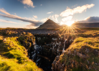 Sunset over Stapafell mountain and seagull nest hole on coastline in Arnarstapi village on summer at Iceland