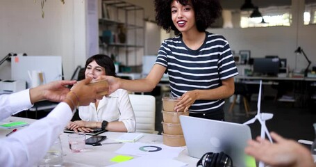 Young businesswoman bringing lunch boxes for her colleagues in office