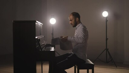 Inspired pianist throws the sheet music paper into the air and plays freely from the heart