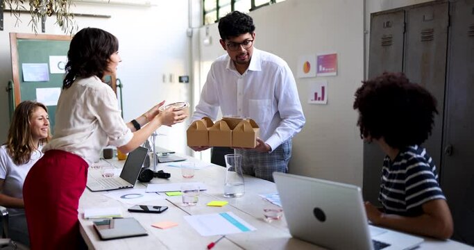 Young businessman bringing lunch boxes for his colleagues in office